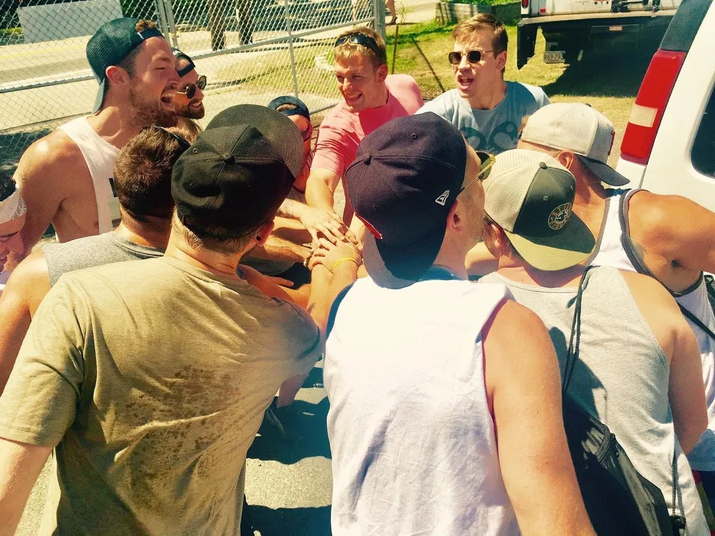A coaching group stacking hands together in a huddle